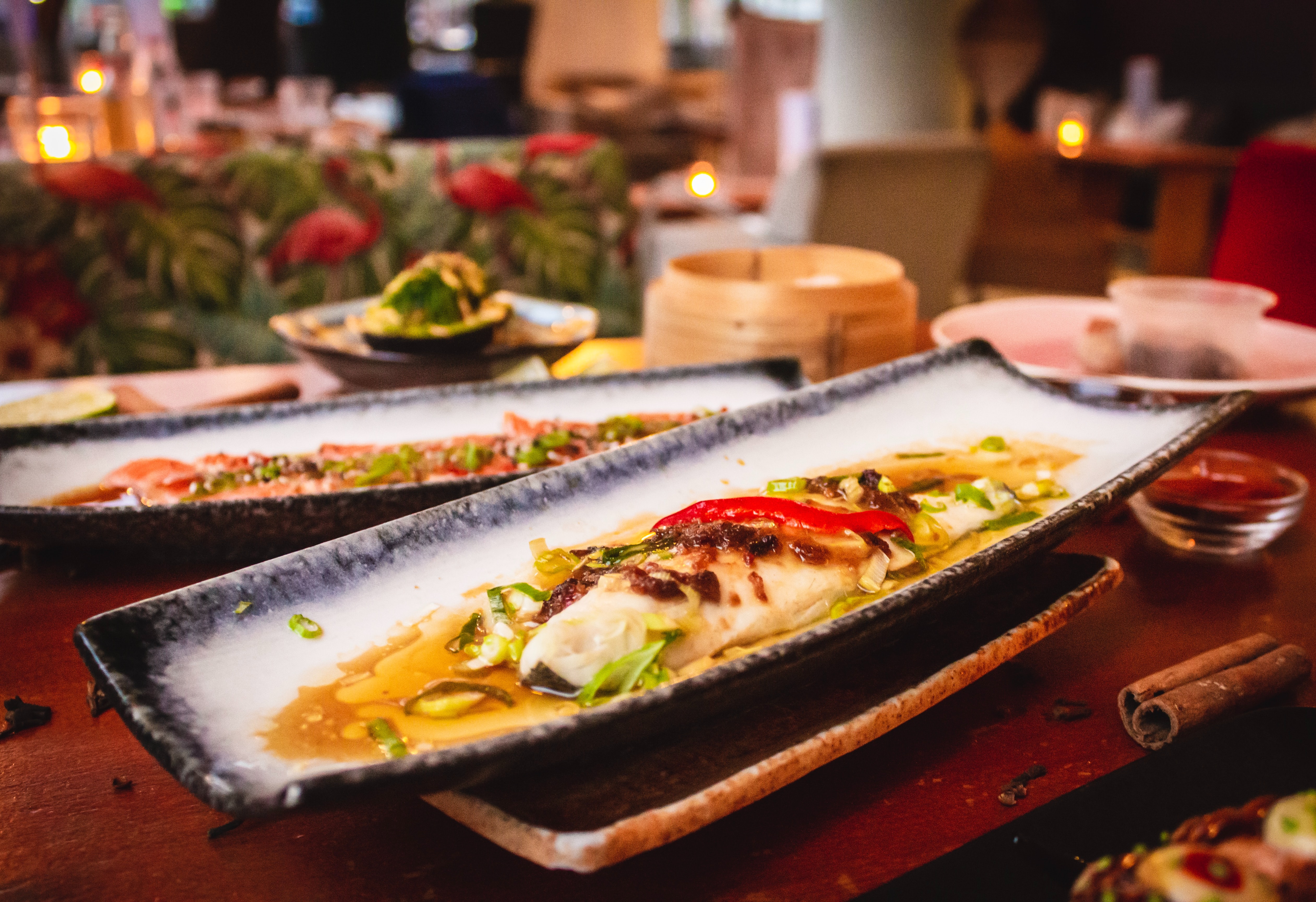 Image d'une assiette appétissante de forme allongée avec du poisson sur une table de restaurant 